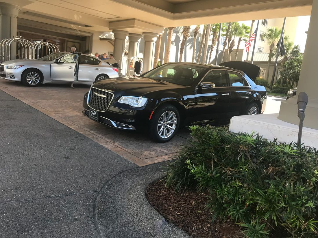 Executive black sedan at a hotel porte-cochère